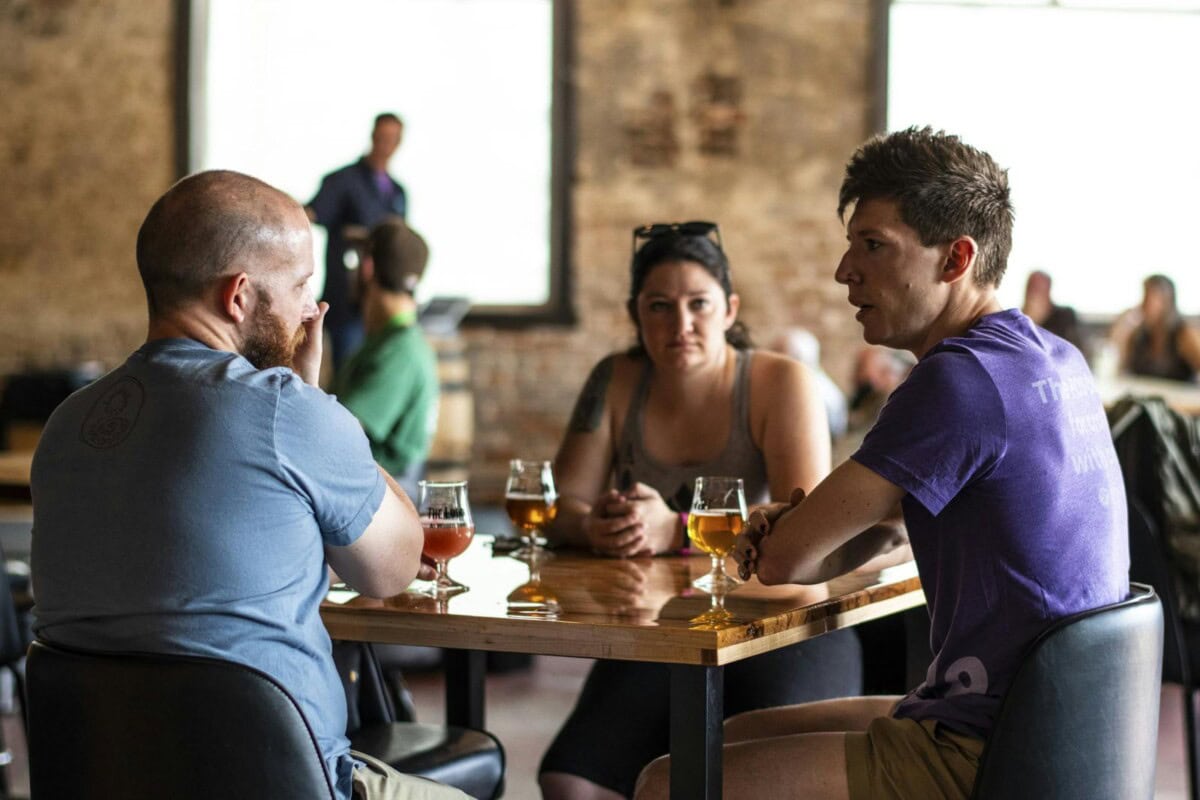 Group conversing while sitting at a table with drinks